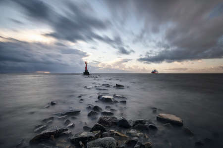 mystical foggy sea and rocky shore in the eveningの写真素材