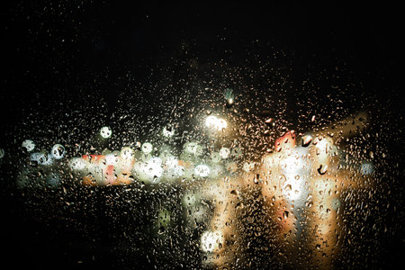 background of glowing lights through raindrops
