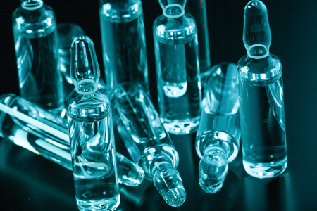 Photo medical ampoules on a dark background in blue-green tintingの写真素材