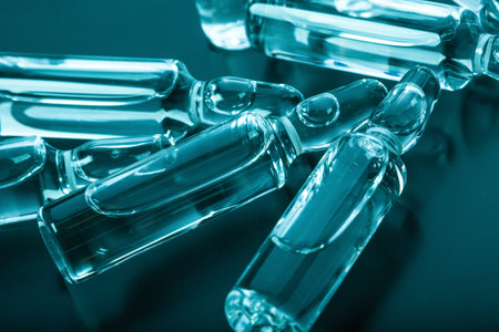 Photo medical ampoules on a dark background in blue-green tinting