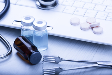 medical devices on the table at the doctor on a light background with wooden texture with blue tonedの写真素材
