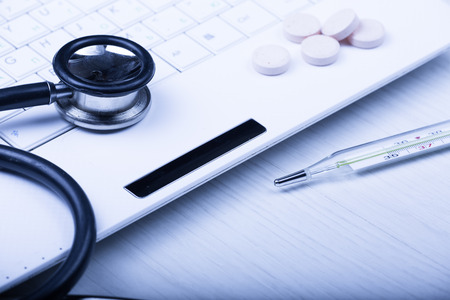 medical devices on the table at the doctor on a light background with wooden texture with blue tonedの写真素材