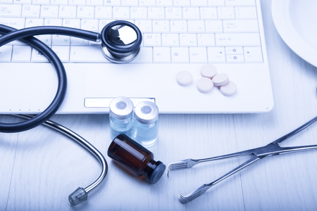 medical devices on the table at the doctor on a light background with wooden texture with blue tonedの写真素材