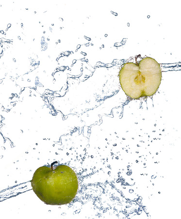 Apple in spray of water. Juicy apple with splash on white backgroundの写真素材