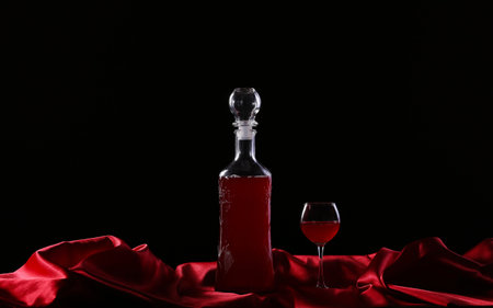 glass and bottle of wine on a dark background silkの写真素材