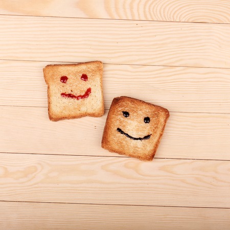 Toast with a smile jam  on wooden table. Breakfast with a smiling toastの写真素材