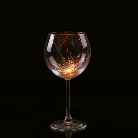 Wine glass with a sparkler. In anticipation of New Year and Christmasの写真素材