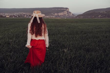 happy laughing girl holding straw walking in the green summer parkの写真素材