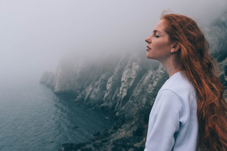 beautiful girl in the morning on the beach. Mysterious girl in the mist, enjoying the humid air....