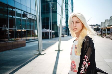 Beautiful young albino woman posing near a business center in Moscow. Japanese fashion, unusual styleの写真素材