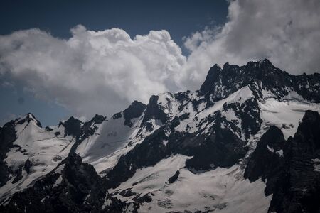 The peak of mount cook above the clouds.. Summer in the mountains. North Caucasus. Dombay. Karachay-Cherkessia, Russia.の写真素材