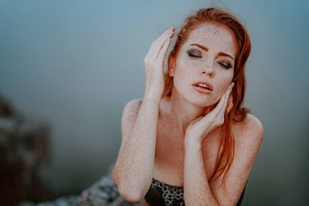 beautiful furious scandinavian warrior ginger woman in grey dress with metal chain mail. Woman is a Viking. Fantasy. Book Cover. Close-up portrait. Cinematic lookの写真素材