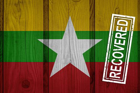 flag of Myanmar that survived or recovered from the infections of corona virus epidemic or coronavirus. Grunge flag with stamp Recoveredの写真素材