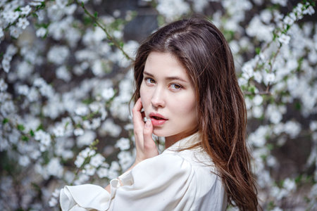 young asian woman in a flowering garden. romantic image of stylish casual woman , trendy silk...