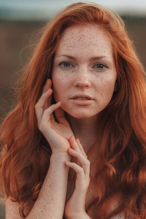 Positive natural close up portrait of young gorgeous caucasian ginger girl with freckles. Healthy lifestyle, beauty, natural concept. Melancholic beautiful portraitの写真素材