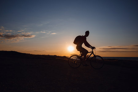 Silhouette of cyclist in motion at beautiful sunset. The idea and concept of a healthy lifestyle,...