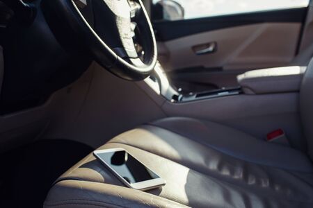 smart phone phone on the car seat dashboard. Lifestyles photo in car. Different views. Without hand, phone.の写真素材