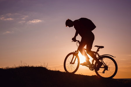 Silhouette of cyclist in motion at beautiful sunset. The idea and concept of a healthy lifestyle,...