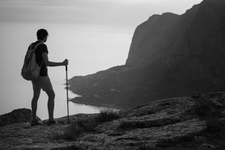 Man hiking at sunset mountains with heavy backpack. Travel Lifestyle wanderlust adventure concept summer vacations outdoor alone into the wild. mock up text.の写真素材