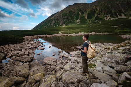 Man Traveler with backpack near mountain lake . Travel Lifestyle concept. Travel and active life...