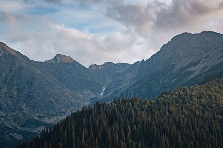 amazing nature, summer in the mountains. Travel and hike. Tatra Mountains in summer time. beautiful panorama of agricultural area. gorgeous mountain ridge with high rocky peaksの写真素材