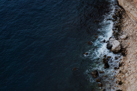 Picturesque seascape with rocky cliffs, stones, sea bay. Danger sea wave crashing on rock coast with...