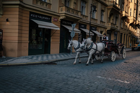 Prague, Czechia - 10.08.2019. The architecture of the old city of Prague. Ancient buildings, cozy streets. A cart with horses rides in the middle of the street of the old city.のeditorial素材