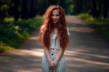 ginger charming woman young beautiful forest green. Caucasian girl relaxing and enjoying life on nature outdoors.の写真素材