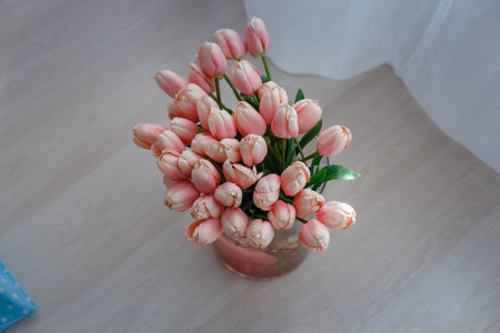 luxury clean bright white interior. a spacious room with sunlight and flowers in vases, with a decorative fireplace, cute pink plaids, and a vase with marshmallows. Idea and concept of a girl's roomの写真素材