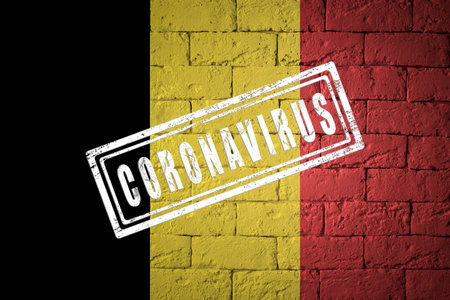 Flag of the Belgium with original proportions. stamped of Coronavirus. brick wall texture. Corona virus concept. On the verge of a COVID-19 or 2019-nCoV Pandemic.の写真素材