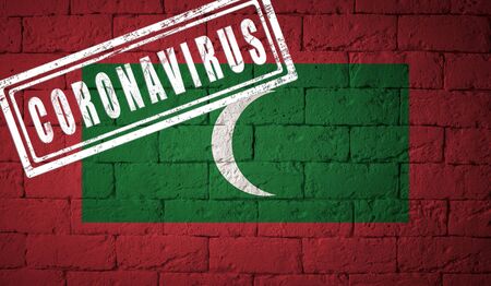 Flag of the Maldives on brick wall texture. stamped of Coronavirus. Corona virus concept. On the verge of a COVID-19 or 2019-nCoV Pandemic. Novel Coronavirus outbreakの写真素材