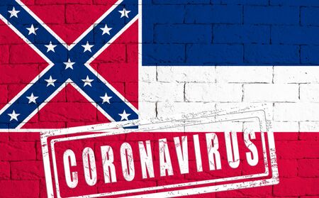 Flag of the State of Mississippi painted on grungy brick wall background. with stamp CORONAVIRUS, idea and concept of healthcare, epidemic and disease in USAの写真素材