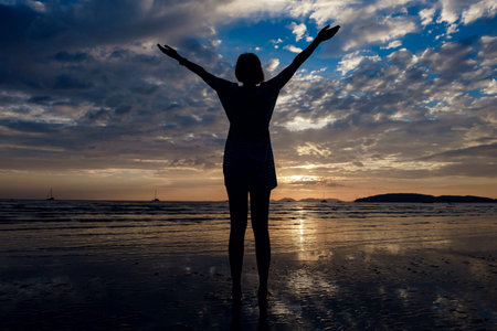 Happy Carefree Woman Enjoying Beautiful Sunset on the Beach. famous Ao Nang beach in Krabi province, Thailandの写真素材