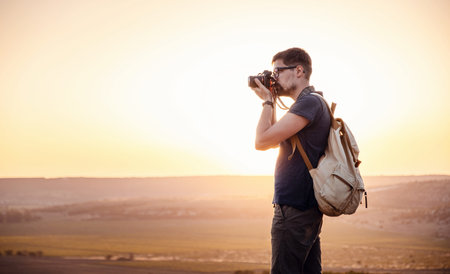 Man photographer with backpack and camera taking photo of sunset mountains Travel Lifestyle hobby...