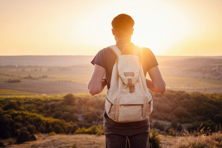 A man standing on a mountain as the sun sets. Goals and achievements concept photo composite....