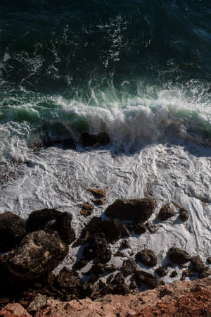 Ocean wave background breaking sea water rocky shore rough seas turquoise water gradient foam. Big waves at open sea. Summer monsoon. White crest of a sea wave.の写真素材
