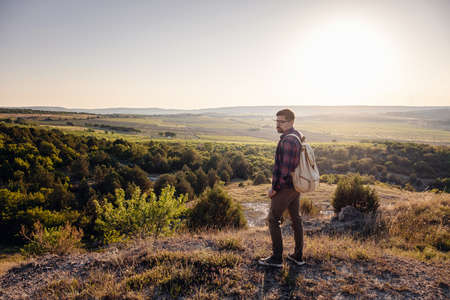 A man standing on a mountain as the sun sets. Goals and achievements concept photo composite. Concept vision, Hiker looking mountain and enjoying sunriseの写真素材