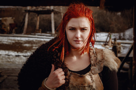 Viking girl. Reconstruction of a medieval scene. Against the backdrop of a large viking village.