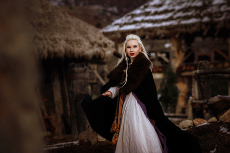 Beautiful blonde Viking dressed in a black cloak against the backdrop of the castle. beautiful film...