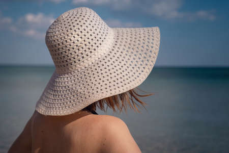 Beautiful Young Woman At Beach Wearing Hat. summer holidays, vacation, travel and people conceptの写真素材