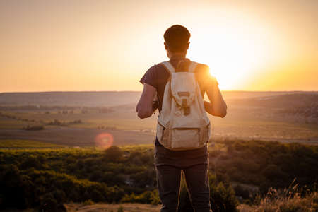 A man standing on a mountain as the sun sets. Goals and achievements concept photo composite. Concept vision, Hiker looking mountain and enjoying sunriseの写真素材