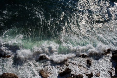 Ocean wave background breaking sea water rocky shore rough seas turquoise water gradient foam. Big...