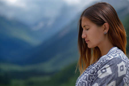 Stylish female hipster walking on top of mountains. Happy young woman exploring sunny mountains. Travel and wanderlust concept. Amazing atmospheric moment. North Caucasus, Dombai, Russia.の写真素材