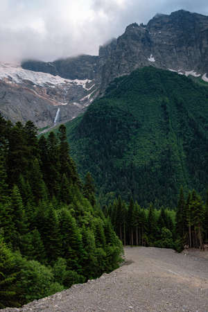 Dramatic mountain landscape. Summer in the mountains. Rain clouds, cold paints, a wildness of greenery. North Caucasus, Dombai, Russia.の写真素材