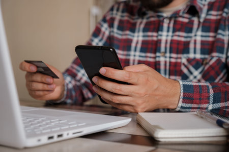 Handsome man using credit card to pay online with smartphone. Shopping Online, Banking system. guy...