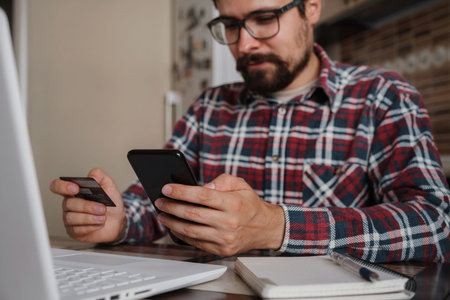Handsome man using credit card to pay online with smartphone. Shopping Online, Banking system. guy...