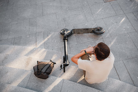 Young Man Accident With An Electric Scooter On Street. A man fell from a scooter on a city street.