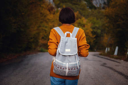 Outdoor fashion photo of young beautiful asian lady surrounded autumn forest in mountains. Portrait of romantic hipster female, Warm autumn weather, calm scene. Wanderlust photo series.の写真素材