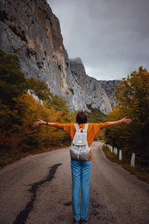 Outdoor fashion photo of young beautiful asian lady surrounded autumn forest in mountains. Portrait of romantic hipster female, Warm autumn weather, calm scene. Wanderlust photo series.の写真素材