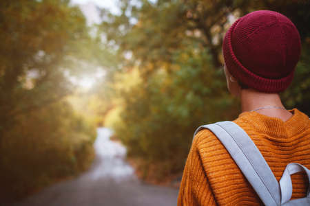 Outdoor fashion photo of young beautiful asian lady surrounded autumn forest in mountains. Portrait of romantic hipster female, Warm autumn weather, calm scene. Wanderlust photo series.の写真素材